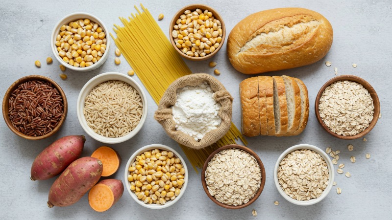 Izbor živil za polnjenje z ogljikovimi hidrati pred maratonom: testenine, riž, kruh, oves in sladki krompir, posneto od zgoraj