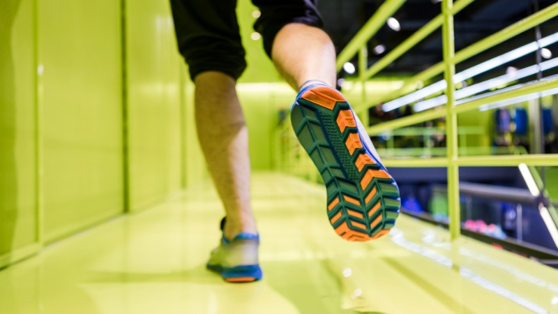 Od blizu posnet podplat tekaškega copata med tekom v specializirani trgovini, kar ponazarja pomen izbire prave obutve.