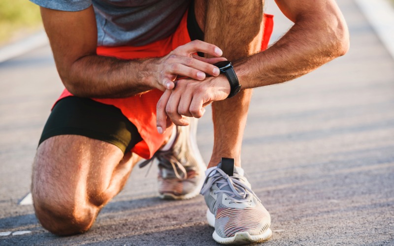 Zapestje tekača s športno uro, ki prikazuje srčni utrip, orodje za natančno spremljanje intenzivnosti treninga v coni 2.