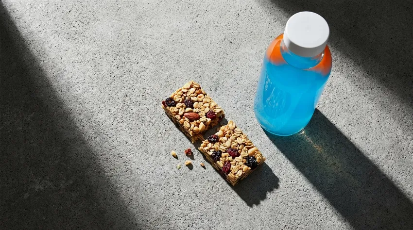 Energijska ploščica in sladka pijača na mizi