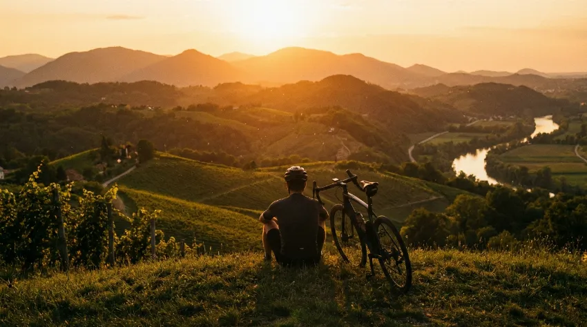 Kolesar ob sončnem zahodu na vrhu hriba
