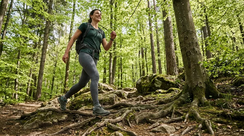 Ženska hodi po gozdni poti v naravi