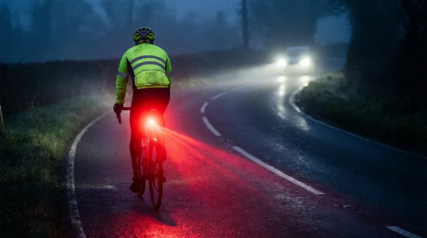 Kolesar ponoči z močno zadnjo lučjo in odsevniki