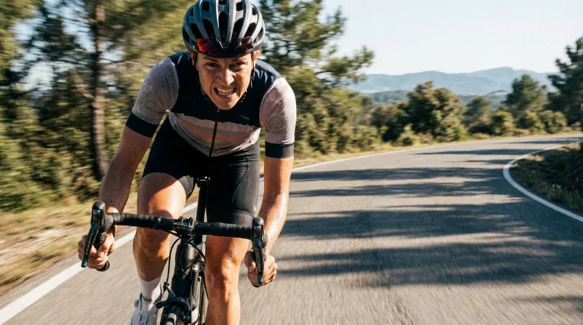 Kolesarka na cestnem kolesu med visoko intenzivnim intervalom