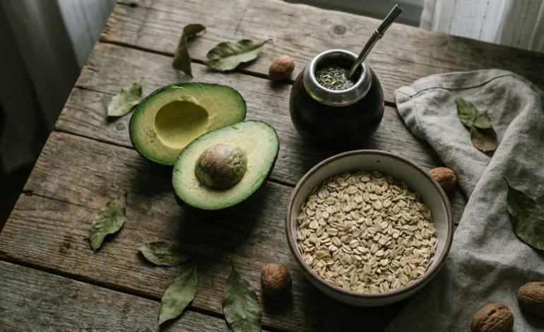 Zbirka živil za naravno hujšanje: avokado, oves in čaj na leseni mizi.