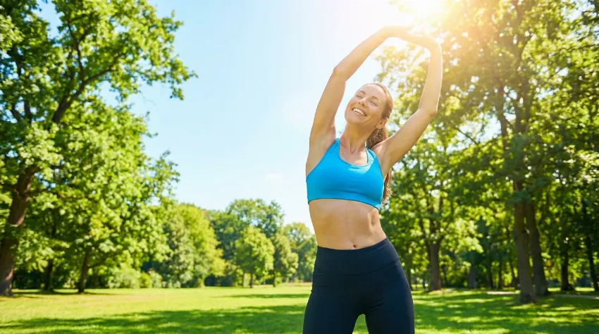 Ženska telovadi na soncu v naravi