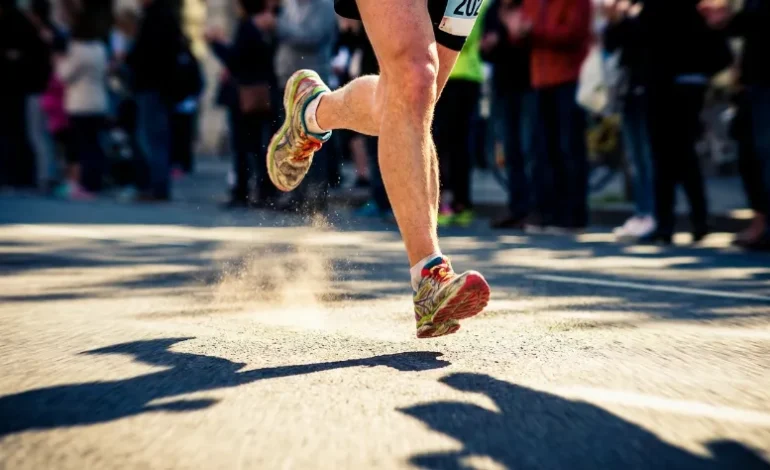 Tekaški copati udarjajo ob asfalt med maratonom.