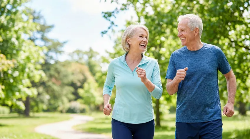 Starejši par sproščeno hodi v naravi brez bolečin v kolkih