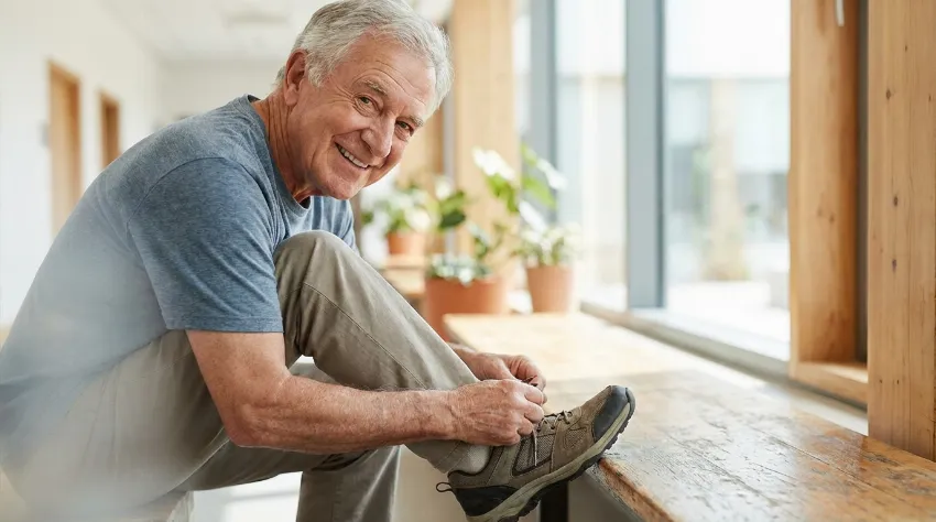 Starejši moški si brez težav zavezuje čevlje