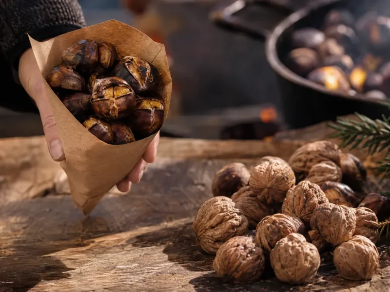 Pečen kostanj v kornetu ob kupčku orehov